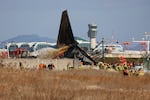 Firefighters and rescue team members work at Muan International Airport in Muan, South Korea, Sunday.