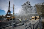 FILE - Workers build the stands for the upcoming Olympic Games on the Champ-de-Mars just beside the Eiffel Tower, in Paris, April 1, 2024 in Paris.