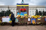 A woman lays flowers at a makeshift memorial on the central square of recently liberated Kherson on Wednesday.