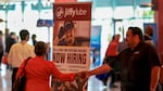 SUNRISE, FLORIDA - APRIL 30: A 'Now Hiring' sign sits next to the Jiffy Lube booth during the Mega JobNewsUSA South Florida Job Fair held in the Amerant Bank Arena on April 30, 2025 in Sunrise, Florida. Over 150 local hiring managers & recruiters were at the job fair to recruit workers for 1000s of positions in Miami, Broward, and Palm Beach County. (Photo by Joe Raedle/Getty Images)