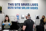 A sign on the wall reads "This site save lives" in Spanish and English at an overdose prevention center.