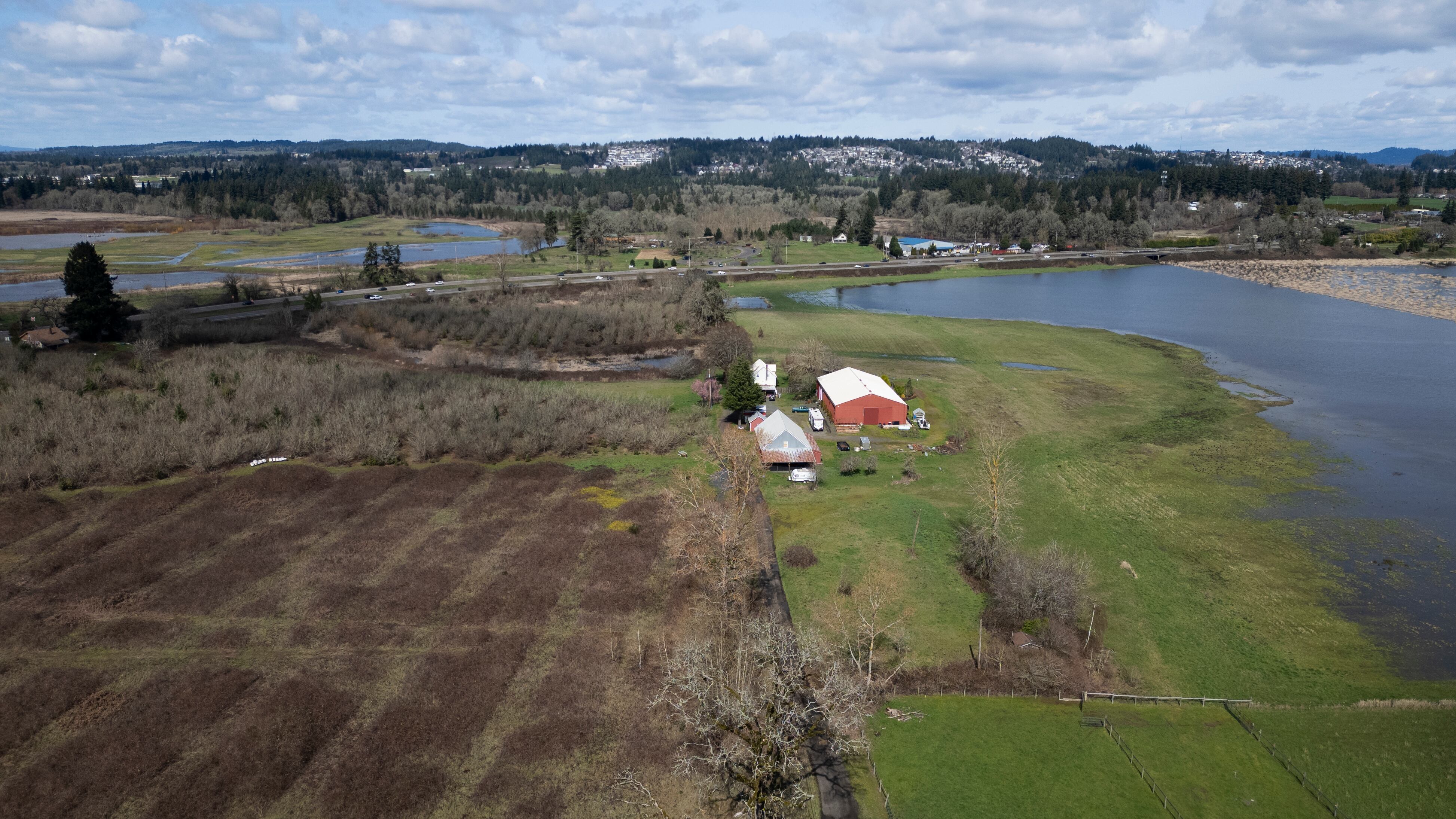 Left, the proposed site for BrightNight’s proposed battery storage facility, is adjacent to Tualatin River National Wildlife Refuge pictured to the right and accross Pacific Highway West on March 14, 2026 in Sherwood, Ore. The proposed power line would run near the stretch of the reserve south of the Highway.