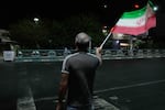A pro-government demonstrator waves an Iranian flag in a gathering commemorating the late Iranian Supreme Leader Ayatollah Ali Khamenei at a square in Tehran, Iran, Saturday, July 11, 2026.
