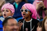 Fans wear pink wigs and stickers with the number of OL Reign forward Megan Rapinoe during the first half of an NWSL soccer match between the Reign and the Washington Spirit, Friday, Oct. 6, 2023, in Seattle.