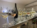 A dozen wine glasses are lined up and considered for sparking wine measurements in the ROCO Winery "tasting laboratory" in Newberg, Ore., Dec. 12, 2024.