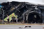 Officials stand near a destroyed wing and engine as they inspect an Amazon cargo plane two days after it overshot a runway at Miami International Airport, Tuesday, Sept. 8, 2026, in Miami.