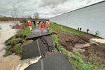 Crews inspect a crack in a levee along the Green River in Tukwila, Wash., Monday, Dec. 15, 2025.