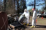 Workers with the Environmental Protection Agency inspect fuel canisters for remnants of hazardous waste on a residential property in Gates.