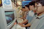 A visitor to a computer exhibition views a website in 1996 in Beijing.