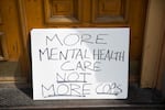 A sign that sits out the entrance of the Cityteam Ministries Shelter reads "More Mental Health Not More Cops."