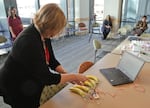 Eugene Public Library director Connie Bennett dinks out a tune on a banana piano created with a Makey Makey circuit board.