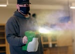 Areas that have been occupied by students at Reynolds High School in Troutdale, are cleaned and sprayed with disinfectant solution. Districts previously committed to distance learning have had to pivot under the governor's executive order to have schools open to in-person learning.