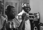 Keyon Harrold plays a trumpet solo as Keith Loftis, tenor sax, and Stafford Hunter, trombone, approve with a "stank face", for The Baylor Project album "The Journey", 2017, at Systems Two Recording studio, Brooklyn, NY, 2014.