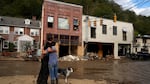 Resident Anne Schneider, right, hugs her friend Eddy Sampson as they survey damage caused by Hurricane Helene in Marshall, N.C. in 2024.