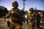 Federal enforcement officers stand guard near a U.S. Immigration and Customs Enforcement facility in Portland, Oregon, Monday, Oct. 6, 2025.