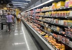 Customers shop in the deli meat aisle of a grocery store in Miami in October.