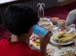 Mujib Ur Rahman plays a video game on a phone. The boy is anxious about his new school; his mother tries to boost his confidence by telling him, "No one is better than you."