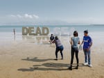 Tourists take pictures near a Dead Sea sign near an Israeli hotel resort.