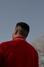 R poses for a portrait behind a restaurant, Saturday, Dec. 21, 2024, in Fremont, Nebraska. He left El Salvador earlier this year and crossed to the U.S. through the CBP One app, now working at a factory in town. His wife and daughter are still in El Salvador. (Lexi Parra for NPR)
