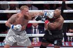 Jake Paul lands a left to Mike Tyson during their heavyweight boxing match on Friday in Arlington, Texas.