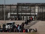 Migrants walk into U.S. custody after crossing the border from Mexico, Ciudad Juarez, Wednesday, March 29, 2023.