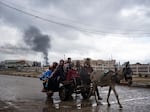 Palestinians flee from the city of Khan Younis in southern Gaza after an Israeli ground and air offensive on Monday, Jan. 29.