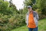 Harry Keaton Moore Jr., 84, Buster's nephew, is wearing a baseball hat and a jacket over an orange shirt.