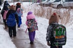 Students walk from a bus at a St. Paul School District elementary school in St. Paul, Minnesota, U.S., March 18, 2026.