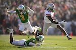 Ohio State wide receiver Jeremiah Smith (4) dashes past two Oregon defenders for the game's opening score, Wednesday, Jan. 1, 2025, in Pasadena, Calif. Ohio State won 41-21, ending the Ducks' season.