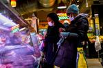 FILE - Customers wear face masks to protect against the spread of the coronavirus as they shop at the Reading Terminal Market in Philadelphia, Feb. 16, 2022. COVID cases are starting to rise again in the United States, with numbers up in most states and up steeply in several. One expert says he expects more of a “bump” than the monstrous surge of the first omicron wave, but another says it’s unclear how high the curve will rise and it may be more like a hill. (AP Photo/Matt Rourke, File)