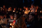 People mourn during the candlelight vigil at Drake Park after three children and a teacher were killed in a shooting at Silver Rail Elementary School in Bend, Ore. on Oct. 15, 2026. The suspected shooter was a 16-year-old who entered the school and was killed by an armed bystander, bringing the total number of deaths to five.
