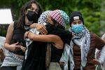 Pro-Palestinian protestors hug each other on George Washington University's campus in Washington, D.C. on May 9, 2024.