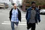 In this March 25, 2016 photo, Jerald Brooks, right, one of the original participants in a Seattle program called Law Enforcement Assisted Diversion, or LEAD, walks down a sidewalk to go shopping for groceries with Chris Cates, left, his caseworker, in Seattle. Washington state's 2021 Recovery Navigator Program is essentially an expansion of LEAD, helping to guide drug users toward treatment and away from criminal consequences.