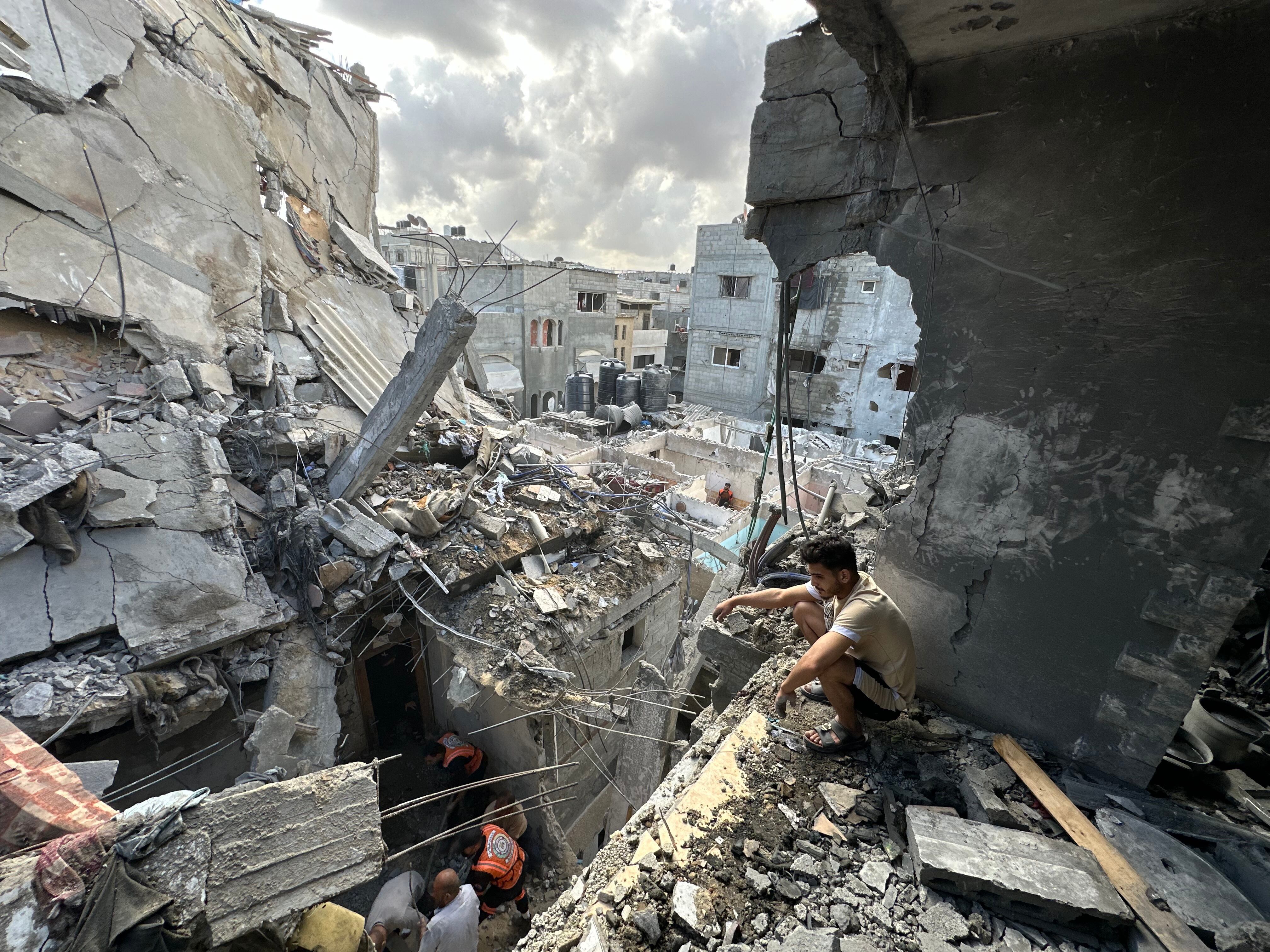 Rescue workers search under the rubble of a building in Rafah outside the evacuation zone that was hit by an Israeli airstrike on Tuesday. Health officials in Gaza say at least 13 people from one family were killed in that attack.