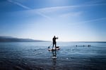 A paddle boarder heads out into the water in Eilat, Israel. Normally, Eilat's beaches and hotels would be busy with tourists.