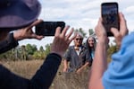 David James, left, and Ida Galash pose with a monarch butterfly fitted with an electronic tag in Oaks Bottom Wildlife Refuge in Portland, Ore., on Sept. 5, 2026. James, an entomology professor at the University of Washington, has been studying the migration patterns of monarchs in the Pacific Northwest for over a decade. 