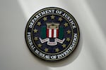 An FBI seal hangs on a wall.