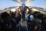 Airline passengers, some not wearing face masks following the end of the federal mask mandate, sit during a American Airlines flight operated by SkyWest Airlines from Los Angeles International Airport to Denver, on Tuesday.