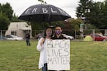 Elizabeth Renguso and her 17-year-old daughter, Sophia, hold a sign during a protest at Revolution Hall, in Portland, Ore.