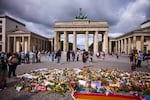 Flowers and rainbow flags placed in front of the Brandenburg Gate commemorating the victims of a car attack on Saturday's Pride March in Berlin, Germany, Monday, July 27, 2026.