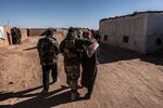 An FSA soldier walks embraced to a Syrian Refugee man in Rukban refugee camp. At the edge of the Jordanian border. Al Tanf, Syria. December 14, 2024.