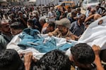 Palestinians carry the body of a journalist who was killed in an Israeli strike on Nasser Hospital in Khan Younis on Aug. 26, 2025. Gaza's civil defense agency said five journalists were killed among at least 20 other people.
