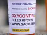 Fake pill bottles with messages about OxyContin maker Purdue Pharma were displayed during a protest outside the courthouse where the bankruptcy of the company was taking place in White Plains, N.Y. in 2021.