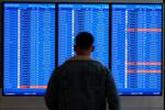 A traveler looks at a flight board with delays and cancellations at Ronald Reagan Washington National Airport in Arlington, Va., on Jan. 11, 2023.