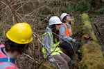 Oregon State student volunteer Shannon Grubbs, left, and Corvallis High School student Belen Hernandez, right, take a break after planting willow saplings. 