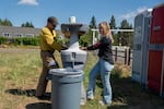Oregon Department of Forestry operations section chief Matt Flock, left, and Bryleemae Braden, who works in clerical and printing support with Fire Dawg, wash their hands at a handwashing station. Officials encourage frequent handwashing at these stations to avoid “camp crud”, a nickname for common sickness that can spread at fire camps.