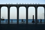 People walk along the waterfront in Yalta, Crimea, on July 21. An estimated 1 million Russian troops and civilians have come to the territory since Russia captured it from Crimea in 2014. But daily life has become increasingly difficult due to Ukrainian drone strikes.