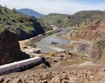 Operators use excavators to remove the remnants of a fish hatchery at the base of Iron Gate dam.