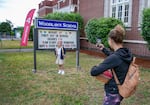 Becca Snyder, right, takes a photo of daughter Ilena Snyder, age 8, on her first day of third grade at Woodlawn Elementary, northeast Portland, Ore., Aug/ 27, 2024.  Elementary students across Portland, as well as sixth and ninth graders, began classes on Tuesday.