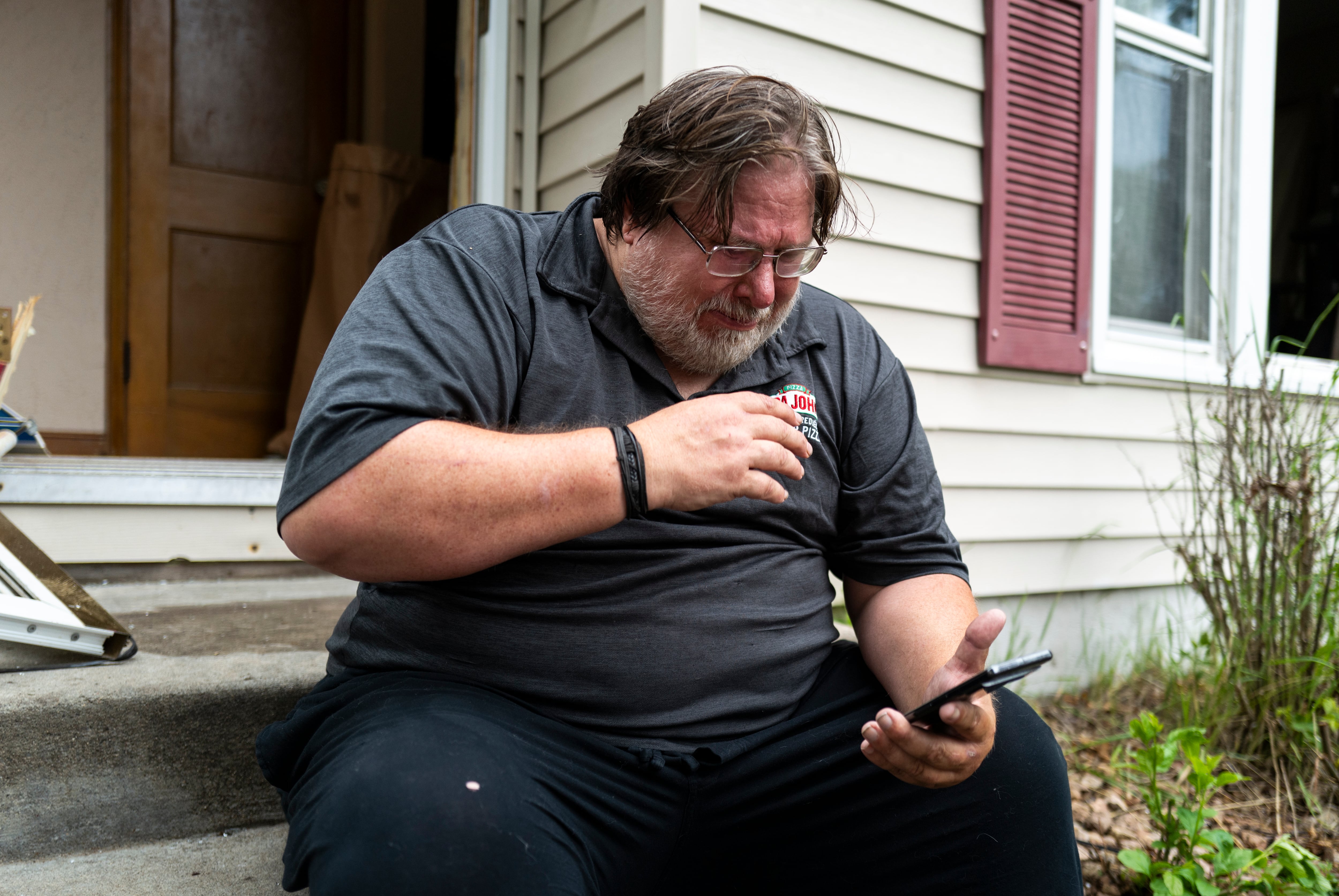 Daniel Carlson reads a text message he received this morning outside his home on June 14, 2025 in Minneapolis, Minnesota. Carlson received a message from Vance Boelter, Carlson's roommate and a suspect in the shooting of two Democratic-Farmer-Labor lawmakers.